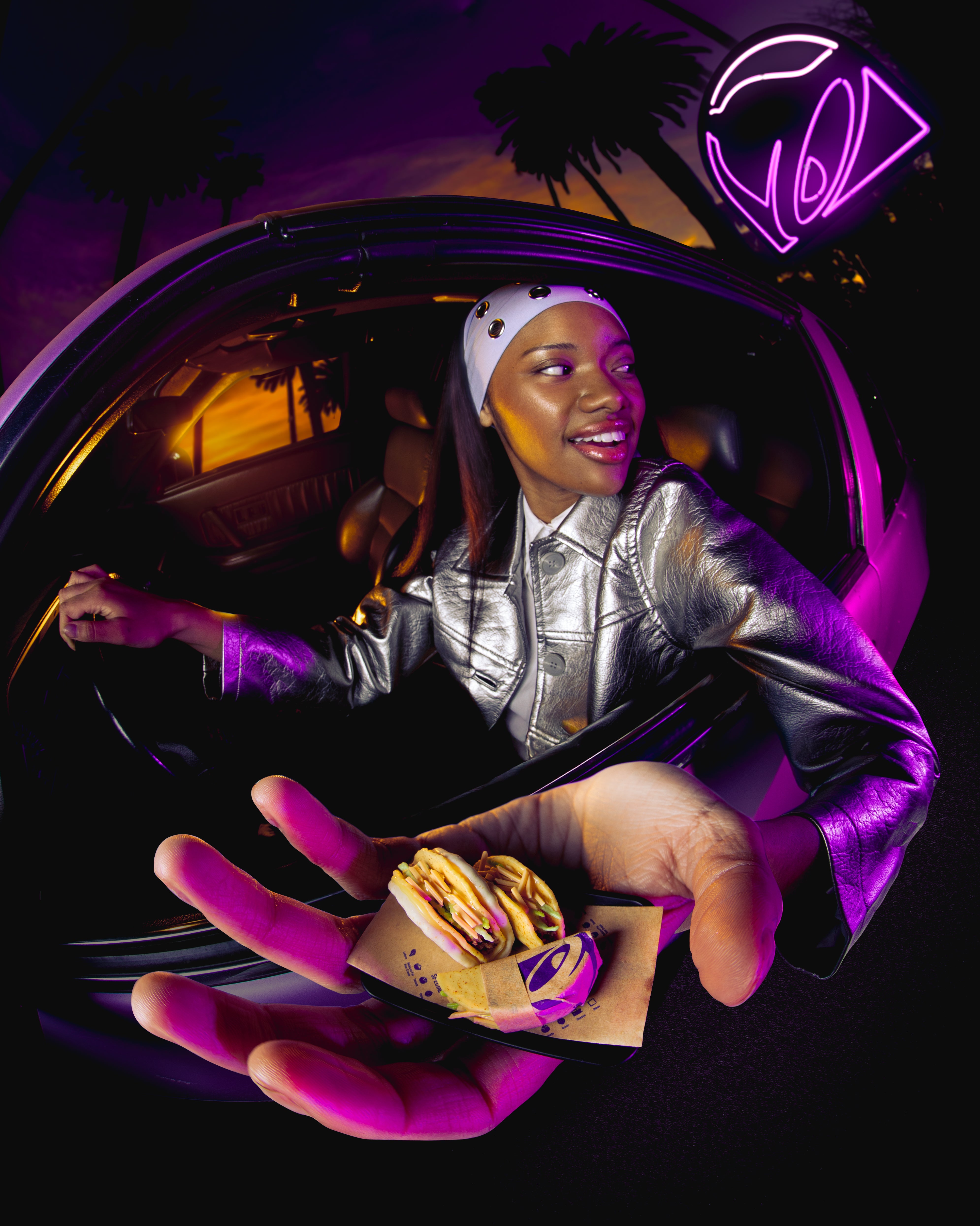 Person in a car holding Miniverse Taco Bell Tacos with a neon sign in the background