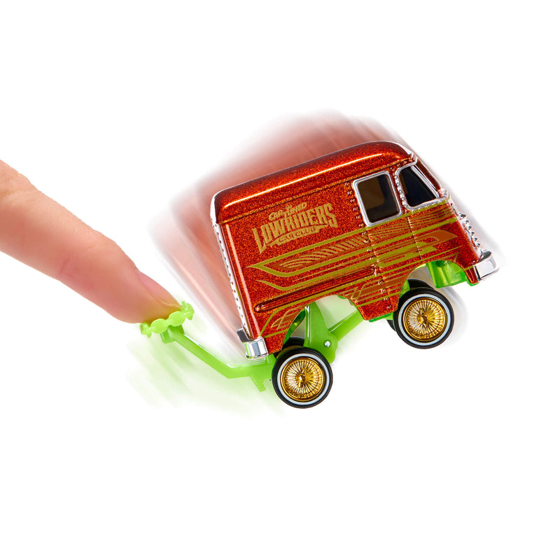 A small toy van with glittery red body, being pushed by a human finger on a plain white background.