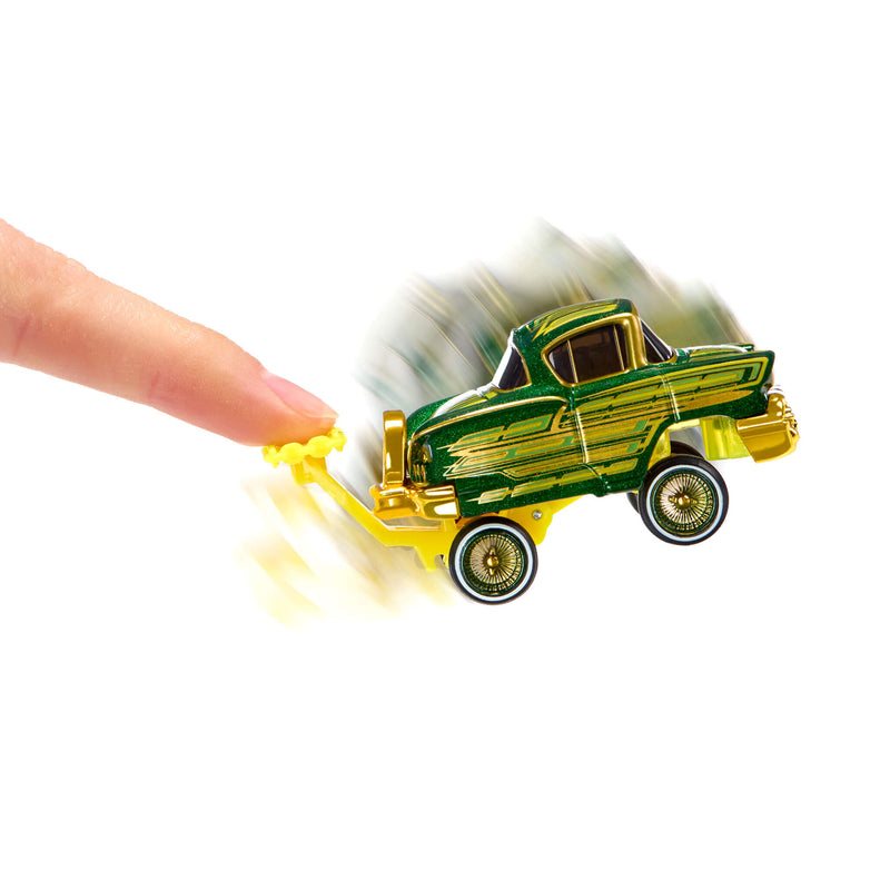 A small toy car with a green and gold striped, being pushed by a human finger on a plain white background.