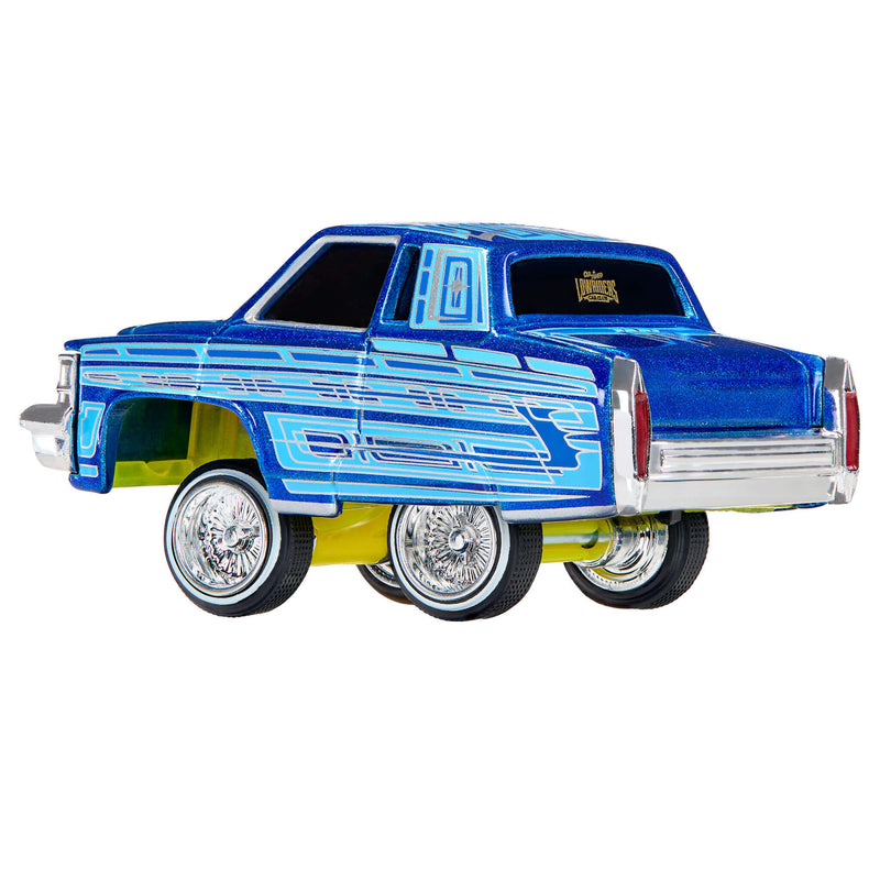 A die-cast metal toy car styled as a classic lowrider, featuring a metallic blue body with light blue graphic stripes, yellow undercarriage, and chrome wheels, shown on a plain white background.