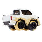 A die-cast metal truck of a Toyota Tacoma, featuring a mud splashed look, white body, and black, dirty tires to show a mud look, shown on a plain white background.