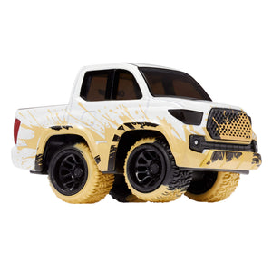 A toy metal truck with a mud splashed look, white body, and black, dirty tires to show a mud look, shown on a plain white background.