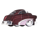A die-cast metal car of a vintage Mercury Coupe, featuring a burgundy body, white trim and a pink fender with black, white wall tires, shown on a plain white background.