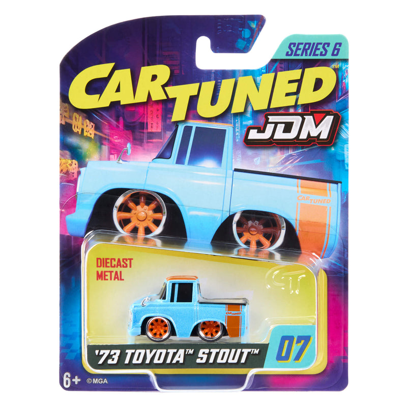 MGA Cartuned JDM '73 Toyota Stout Series 6 diecast metal toy truck in its original blister card packaging. The toy truck is light blue with orange wheels.