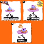 Three-panel instruction graphic showing how to display a mini collectible figurine: step 1 shows a hand applying purple glitter from a tube, step 2 shows the decorated mini on a small purple stand, and step 3 shows the final display with a glass dome lid. The background is bright orange.