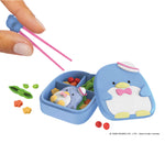 Blue penguin-themed bento box with compartments and a pair of pink chopsticks on a white background.