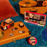 Mini Vintage record player with mini vinyl records and a retro-style music box on a textured blue surface.