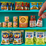 Three teal shelves with mini food; top has different packages of Spam, the middle had Dole Pineapple, Honey Bunches of Oat, jar of sauce; the bottom has Pirates Booty and Skinny Pop popcorn bags.