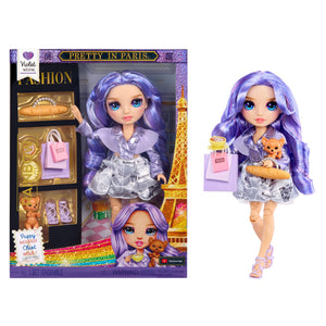 Doll with purple hair and outfit next to its packaging featuring the Eiffel Tower.