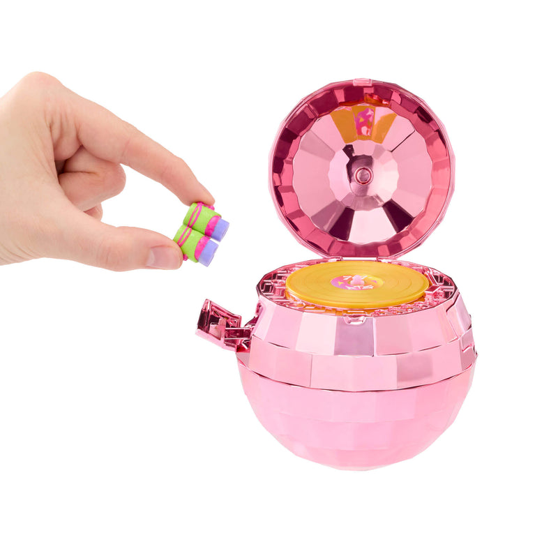 Hand by shiny pink ball with yellow disc in center on a white background
