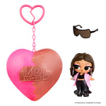 Small doll with short brown hair and sunglasses with a heart shape keychain on a white background