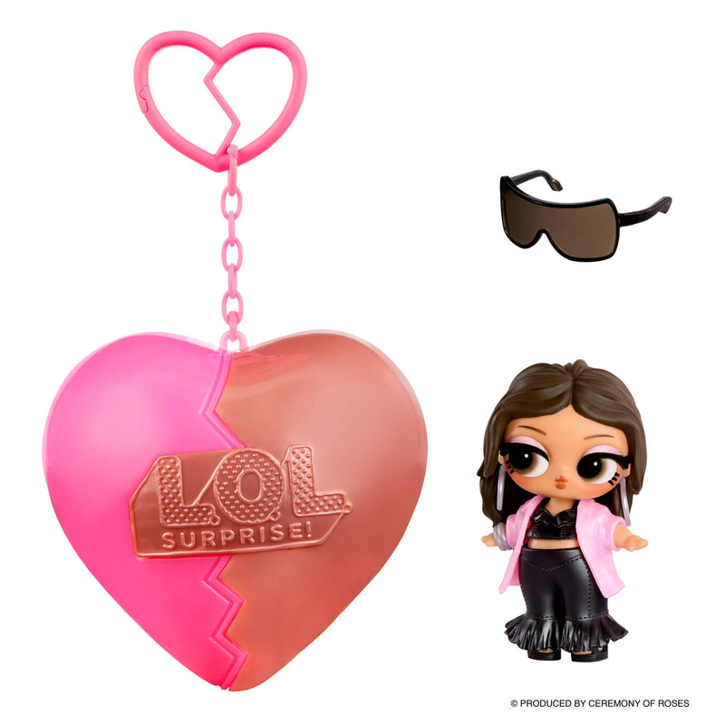 Small doll with short brown hair and sunglasses with a heart shape keychain on a white background