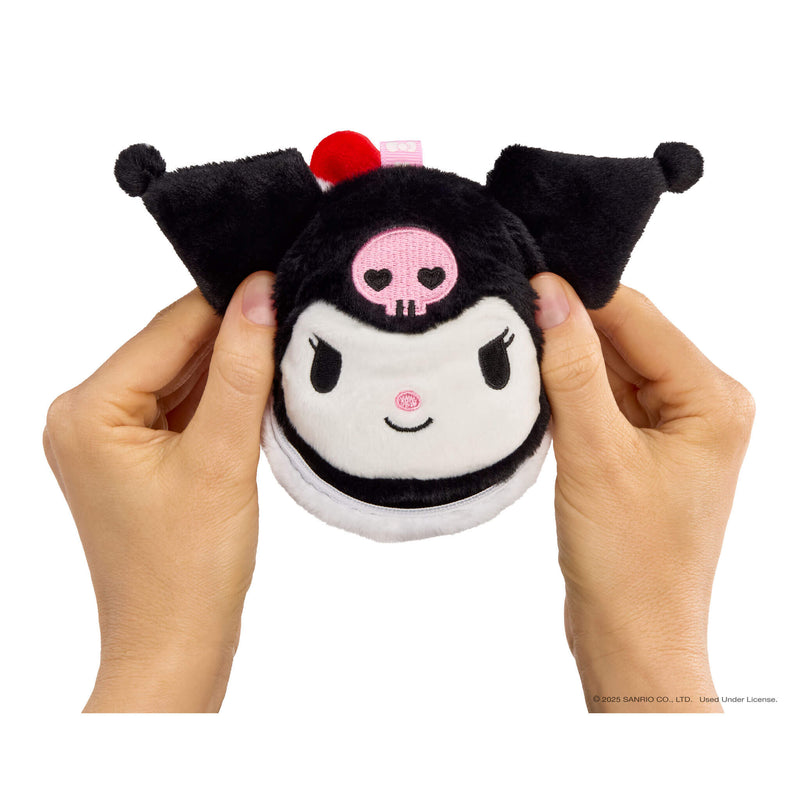 Plush toy with a skull design held by hands on a white background