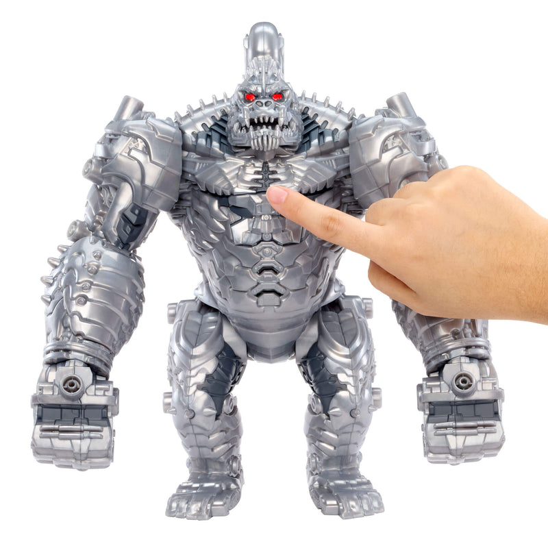 A large metallic silver monster toy with red eyes and a finger pointing at its chest, shown against a plain white background.