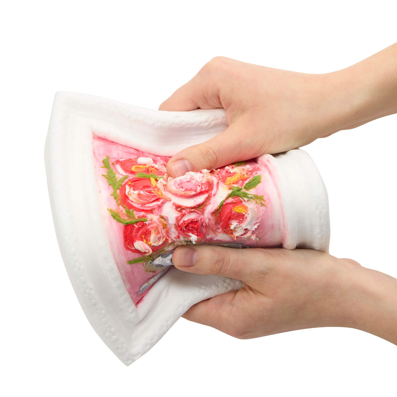 A close-up of the picture being squeezed by two hands, showing a pink floral pattern on the inner side, against a plain white background.