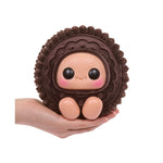 Cookie figurine with a face, held in a hand against a white background