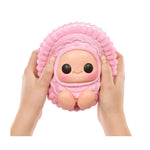 Pink plush toy with a face held by two hands on a white background