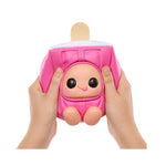 Pink plush toy resembling a popsicle on a stick held by two hands against a white background