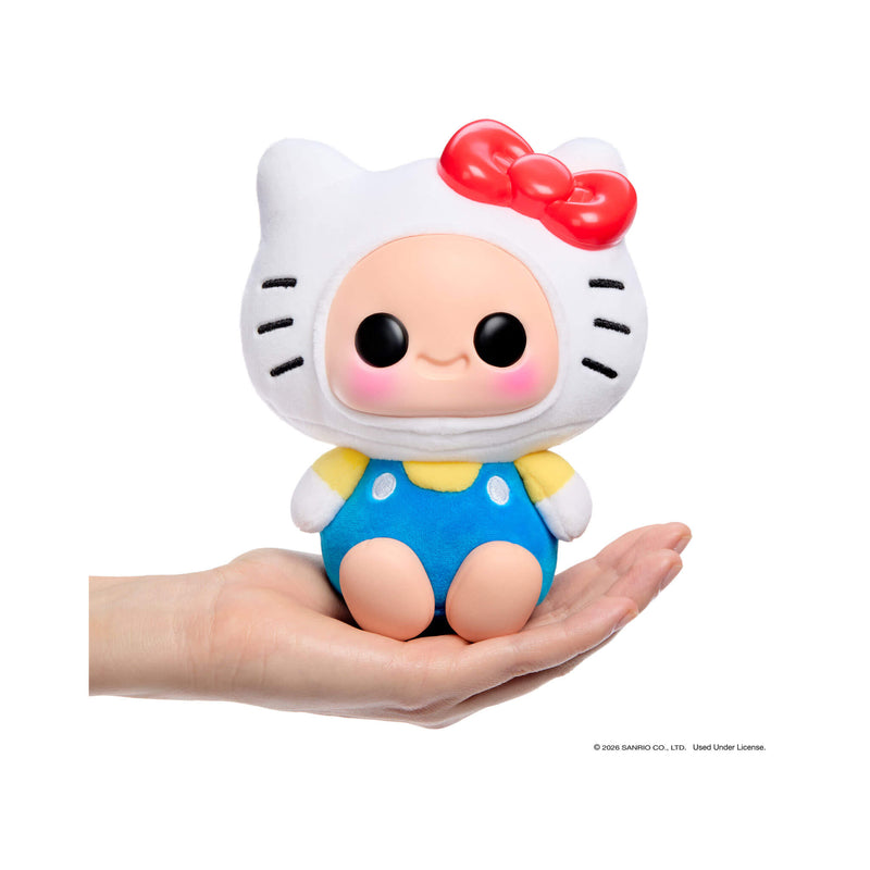 Hello Kitty with a red bow and blue polka dot outfit held in a hand against a white background.