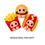 Three character plush toys: Bottom left: red fries’ container with soft, yellow plush “fries” sticking up; a smiling face with large black eyes. Top center: a burger-themed plush -tan bun hood, lettuce and a brown textured “patty” band around its middle. Bottom right: a hot dog–themed plush — tan bun with red hot dog body, yellow squiggle of “mustard.” With text on bottom of the page ‘WHICH WILL YOU GET?’