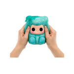 Hands-holding and squishing a Blue Gummy Bear, featuring a cute cartoon face on the front, with blue feet, shown against a plain white background.