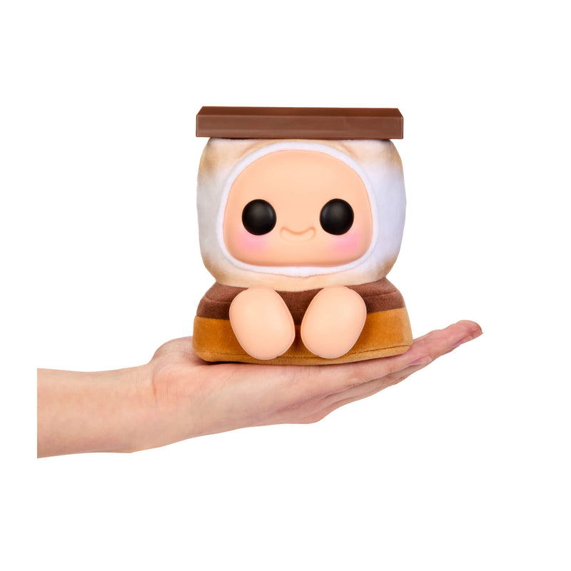 Smore-themed plush, with big black eyes, Rosy cheeks, a smile and feet being held in the palm of a hand, on a white background
