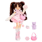 A doll with brown pigtails, wearing a fluffy pink dress and white boots, posed with accessories including a small purple plush, a pink cat-shaped accessory, a pink paw print, and a pink purse on a plain white background.