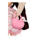 Pink purse with a white keychain on a white background