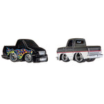 Two die-cast toy pickup trucks on a plain white background. The left truck is black with colorful flame decals in blue, yellow, orange, and red.