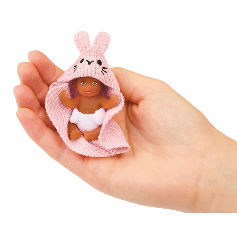 Mini baby sitting in palm of a hand on a white background