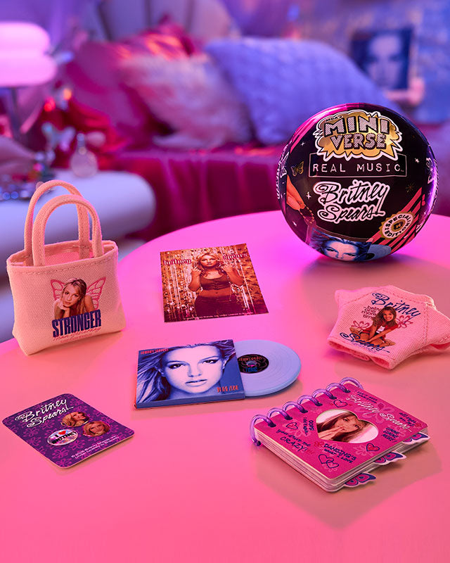 Collection of MGA's Miniverse Real Music Britney Spears Special Edition on a pink surface with a blurred background.