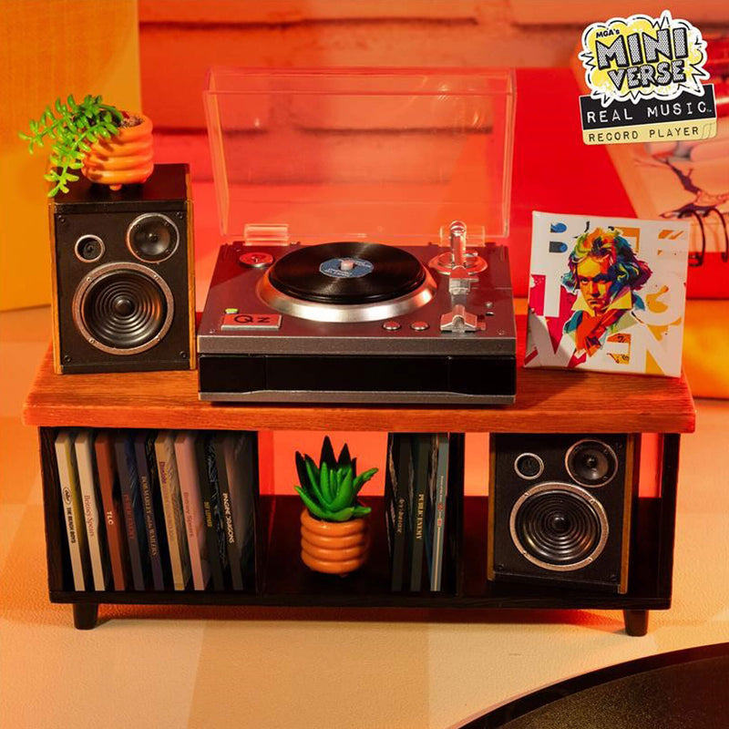 Miniature record player with speakers and records on a wooden shelf against a colorful background.