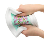 A close-up of the slime picture frame being bent and stretched by two hands, showing a printed floral pattern in pink and green on a mint background.