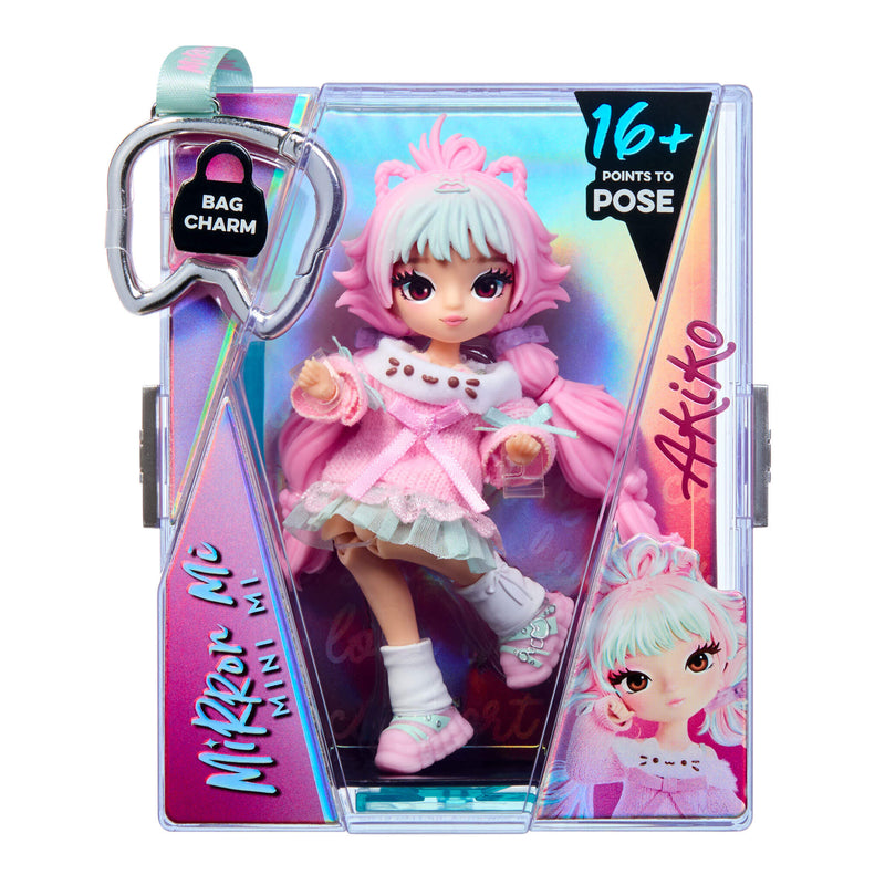 Mirror Mi Mini Mi doll with pink pigtails and blue bangs, pink sweater dress with mint green ribbon details shown inside a keychain, retail packaging on a white background.