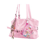 Pink purse with Mini Mi in packaging keychain hanging from a strap on a white background.