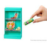 Teal toy vending machine with snacks and a hand holding Mini Pringles package.