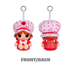 Two views of a strawberry-themed plush doll keychain or bag charm on a white background, labeled FRONT/BACK. The character wears a pink strawberry-patterned bonnet and red outfit, with a light blue hanging strap and metal ring.