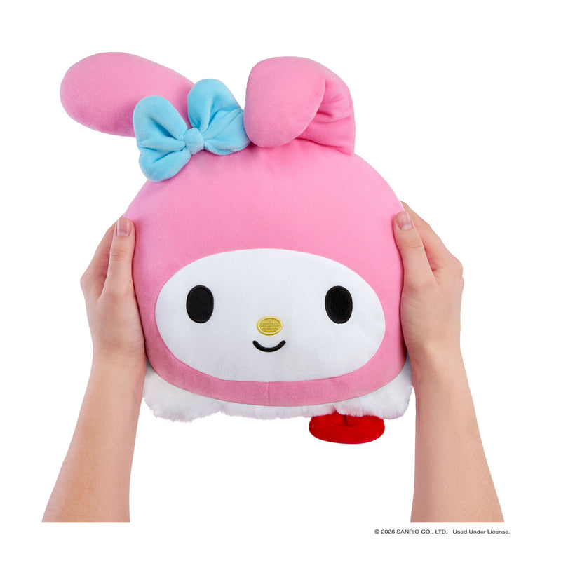 Hands holding a pink looking stuffed bunny with a blue bow and a smiley face, the bottom is showing a little white and red on a white background.