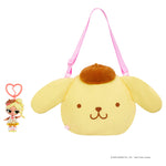 Doll keychain next to a Yellow dog bag with a brown hat on a white background