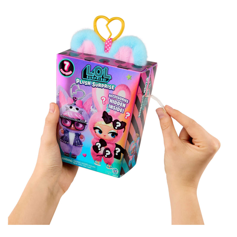 Hand holding a L.O.L. Surprise! plush toy packaging with colorful design.