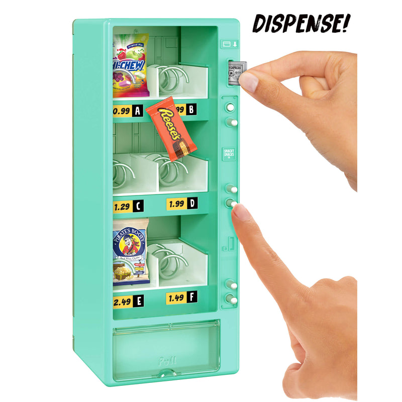 Toy teal vending machine with snacks and a hand pressing the 'Dispense!' button.