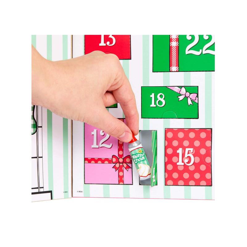 A hand opening one of the numbered Advent calendar doors, which features a striped green and white background with colorful gift boxes numbered 12, 15, 18, and 22. A small miniature 'Merry Cream' gift box is pulled out.