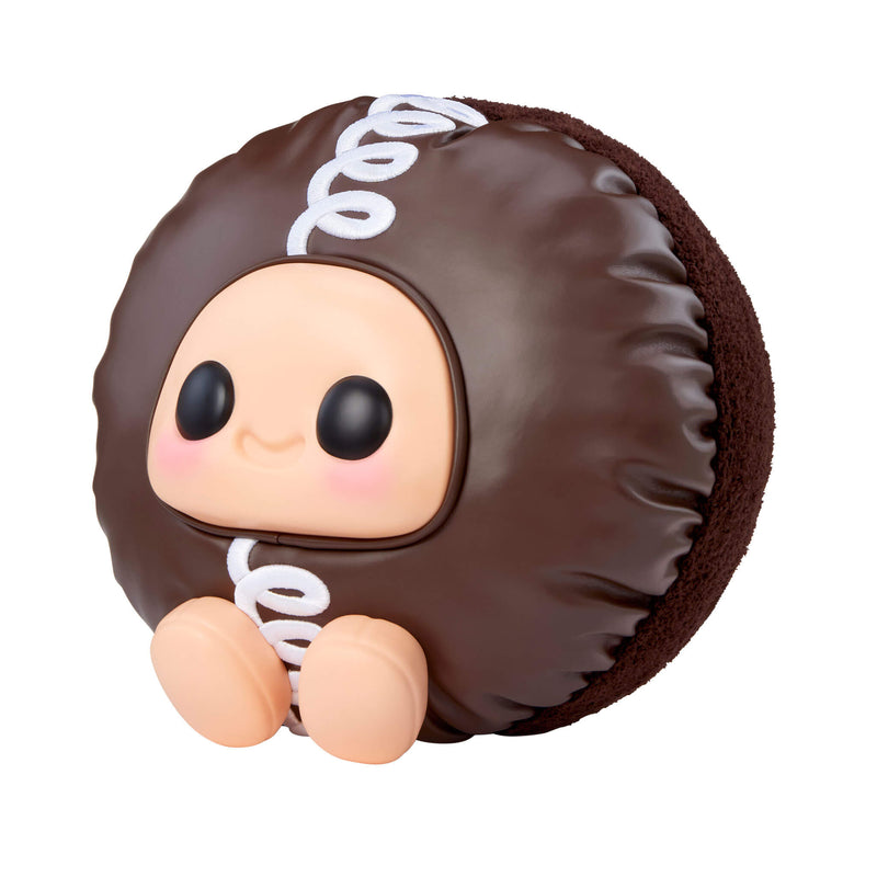 Cupcake sitting to the left with big black eyes and a smile on a white background