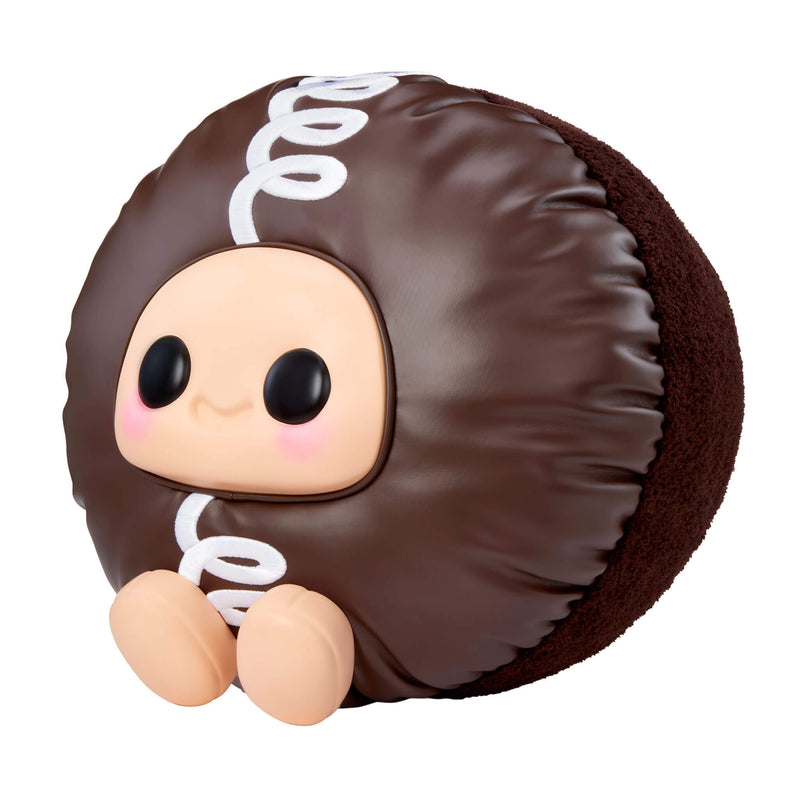 Cupcake sitting to the left with big black eyes and a smile on a white background