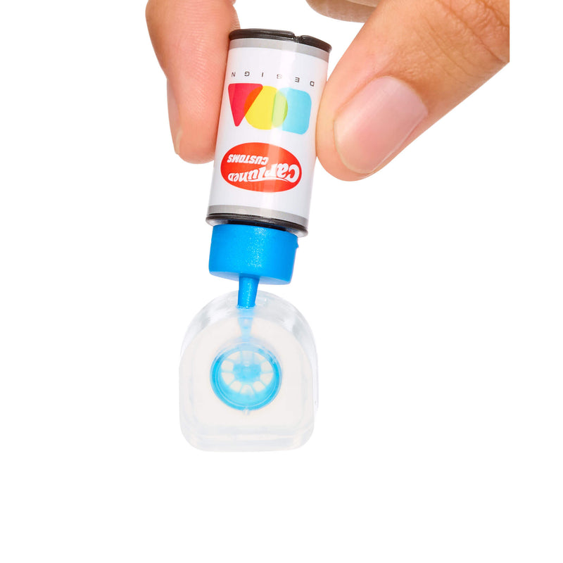 Adding resin to rim mold. Small bottle with a blue cap held by a hand on a white background