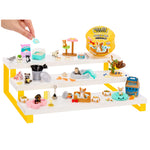 A mini animal pet display set with three white shelves and yellow legs, filled with miniature pet accessories, toys, and figurines. A human hand is placing a small item into the top slot.