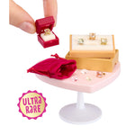 Miniature jewelry set with rings and a box on a small table, labeled 'Ultra Rare'.