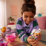 Young girl playing with a toy figure in a room with a pink couch and plant.