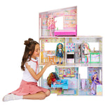 Girl playing with a dollhouse featuring multiple dolls and rooms.