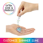 Hand holding a small container of shimmer slime with text 'Extra Slime & Sparkles' and 'Customize Shimmer Slime'.